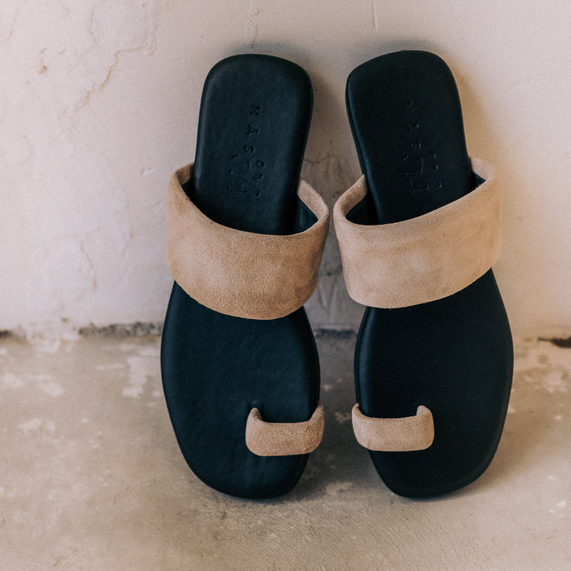 Flat sandal easy to put on and take off with natural color suede toe ring.