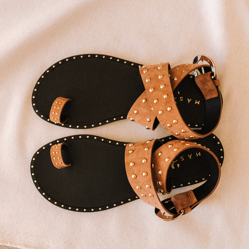 Flat sandals with crossed straps in cognac suede and golden studs