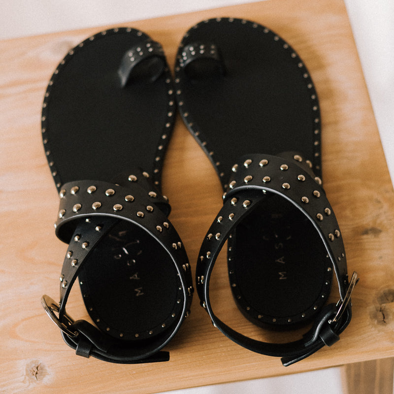 Flat sandals with toe ring and crossed straps in black leather