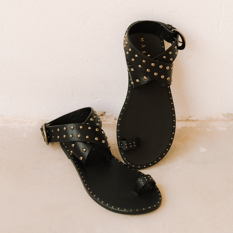 Sandals with crossed straps and golden studs in black leather