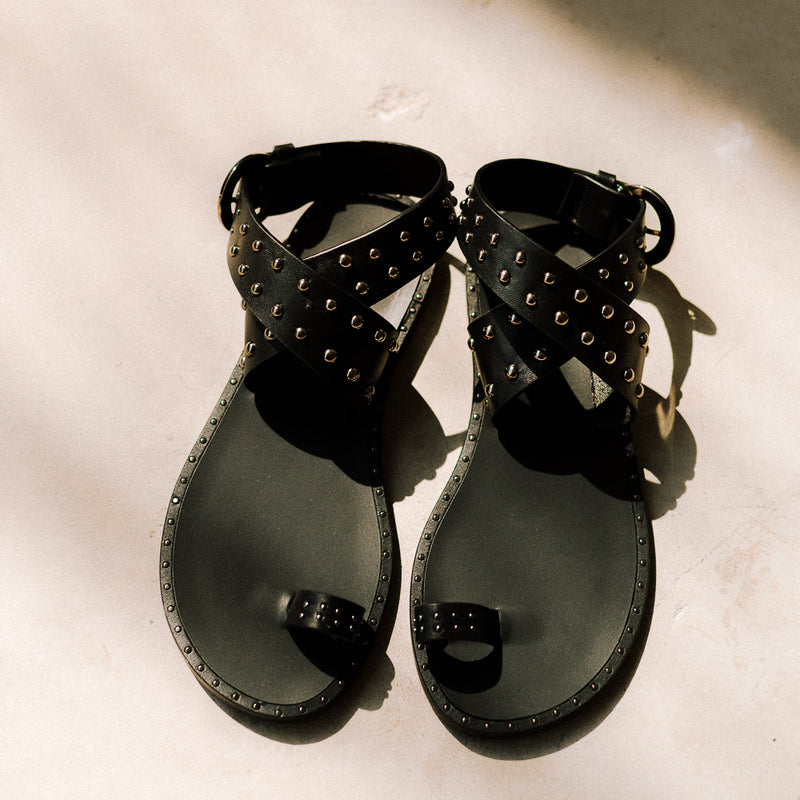 Flat sandals with studs in black leather