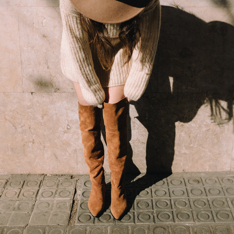 Chica vistiendo un par de botas marrones tipo mosquetera