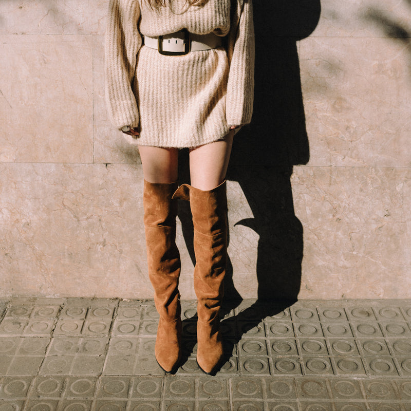 Mujer posando de frente con unas botas altas marrones tipo mosquetas hechas en ante
